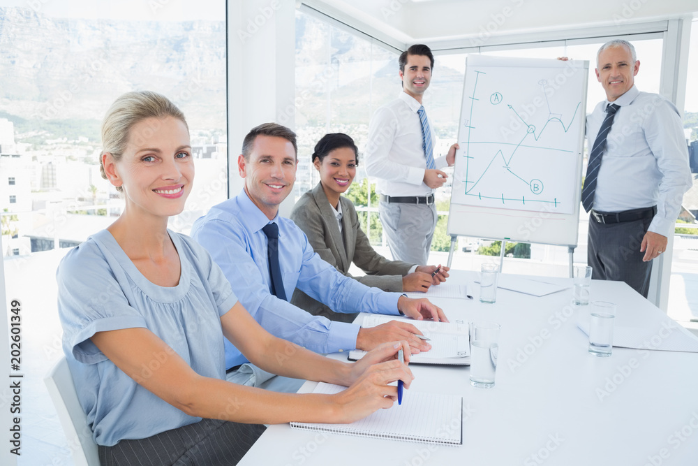 Business team during meeting smiling at camera Business team during meeting smiling at camera