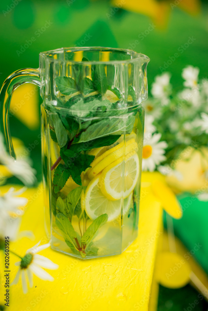 carafe with lemonade around the flowers of chamomile carafe with lemonade around the flowers of chamomile