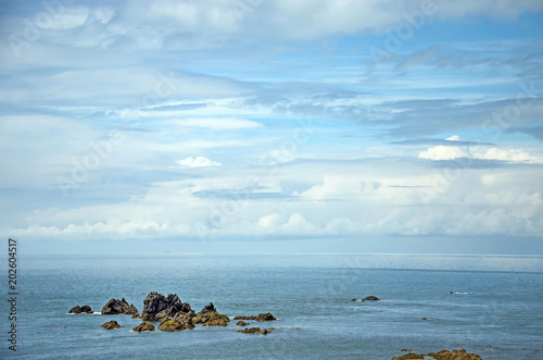 Very diverse cloudshape with all shades between white and blue above a few little rocky islands off the Cornwall coast