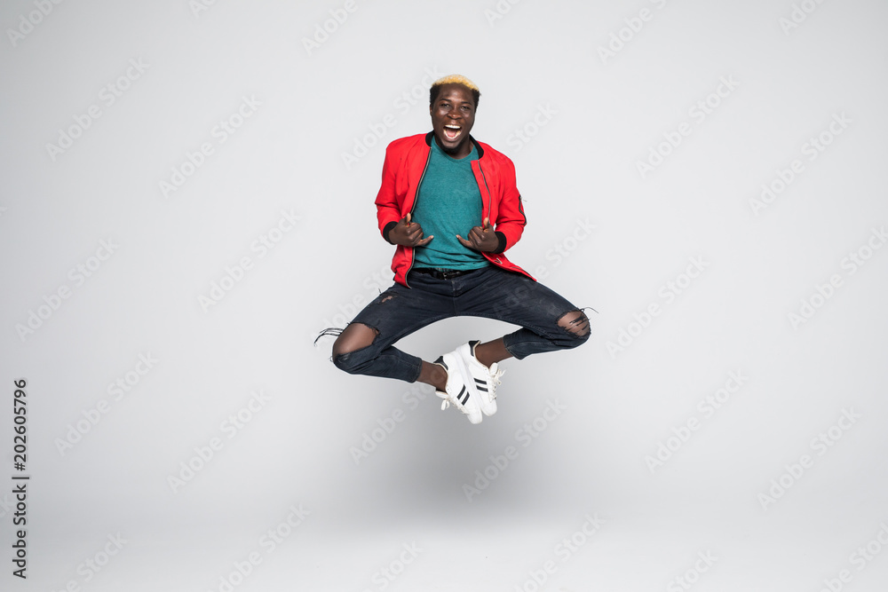 Young handsome afro american man jumping over isolated white background.