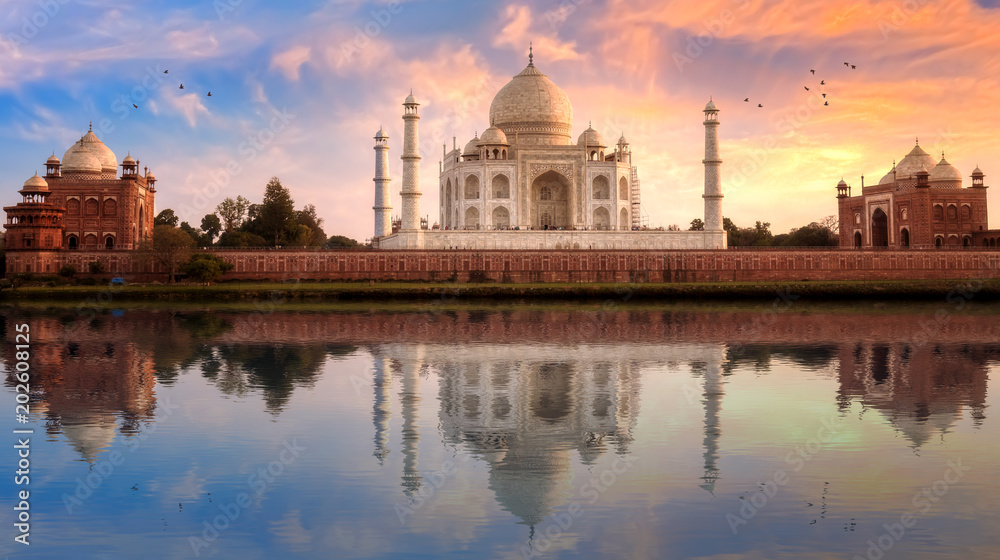Taj Mahal Agra with view of east and west gate at sunset with water reflection.