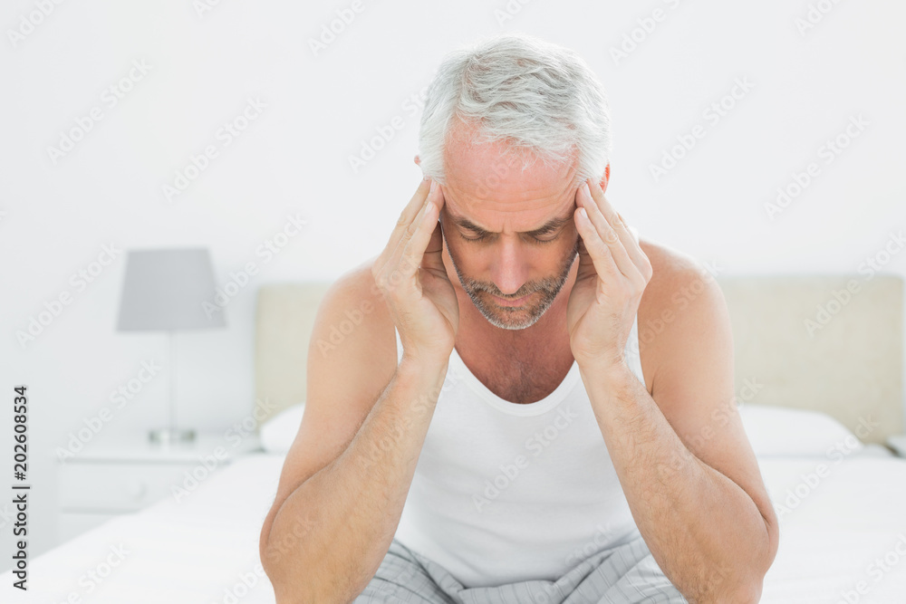 Man suffering from headache in bed Man suffering from headache in bed