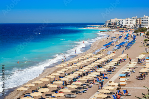 Aegean beach with sunshades in city of Rhodes (Rhodes, Greece)