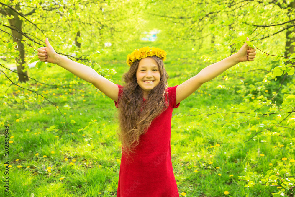 Φωτογραφία Little girl in red dress and crown of dandelions showing thumbs up symbol