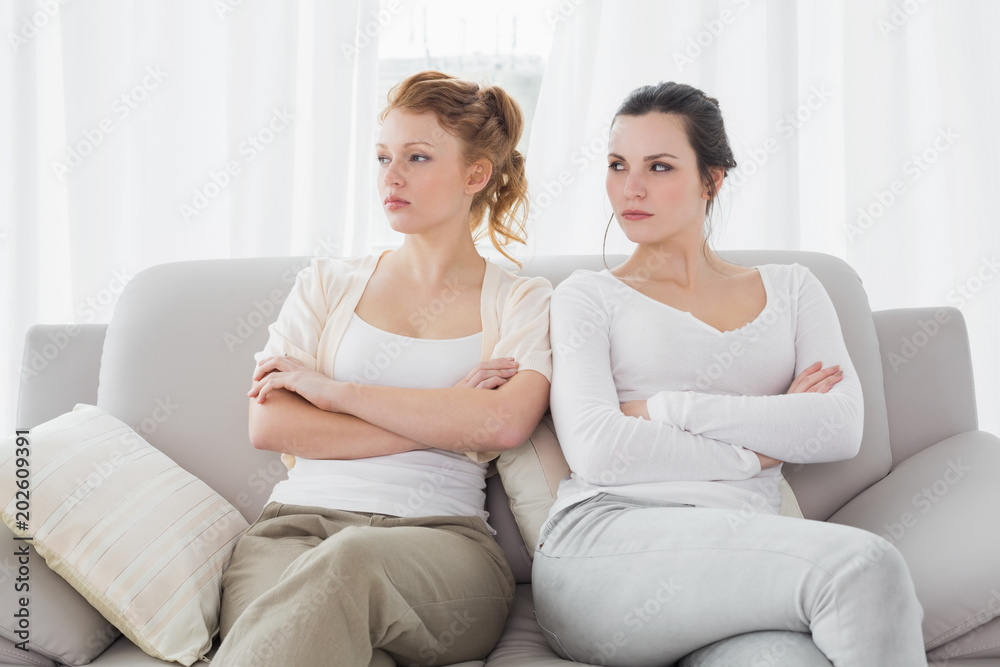 Unhappy friends not talking after argument on the couch Unhappy friends not talking after argument on the couch