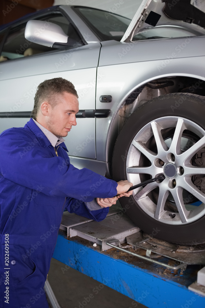 Mechanic unscrewing a bolt with a wrench Mechanic unscrewing a bolt with a wrench