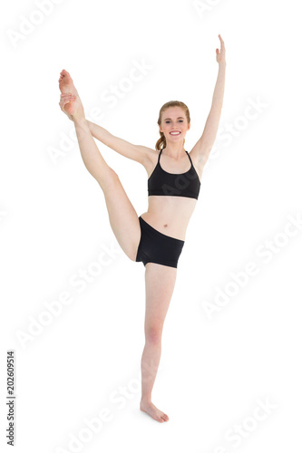 Full length of a sporty young woman stretching leg