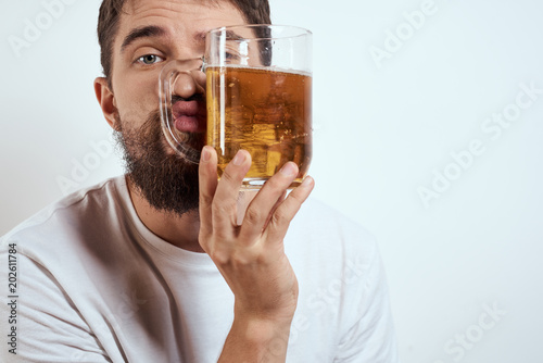 A man holds a glass of beer in the face