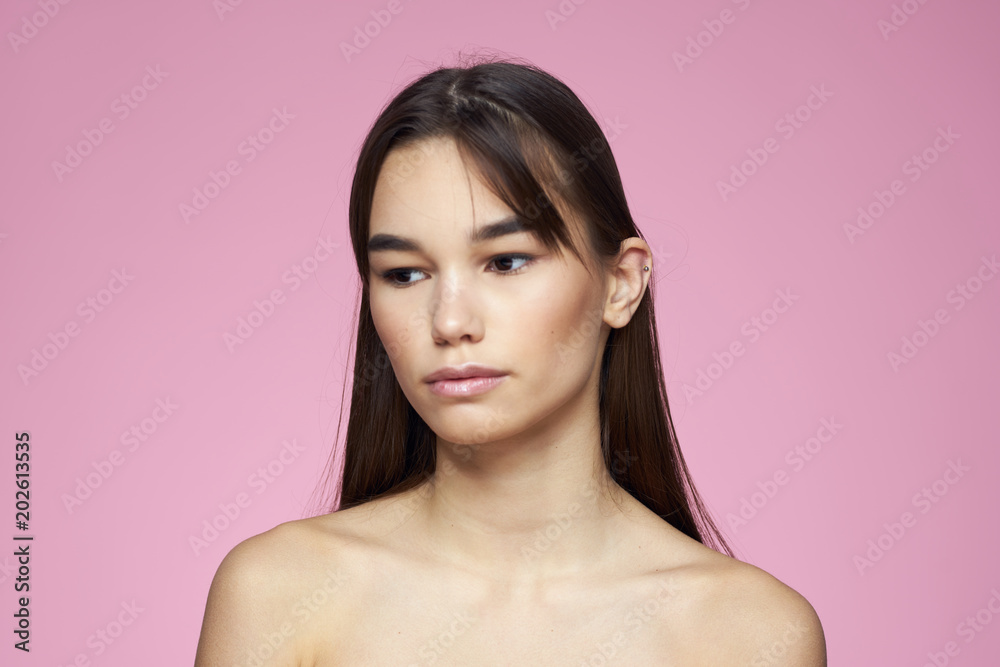 woman with dark hair on a pink background