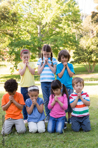 Children saying their prayers in park © WavebreakmediaMicro