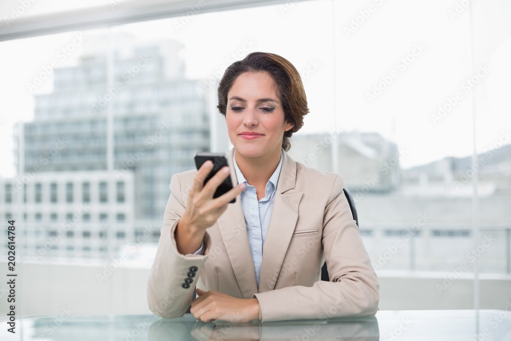 Businesswoman smiling at her smartphone