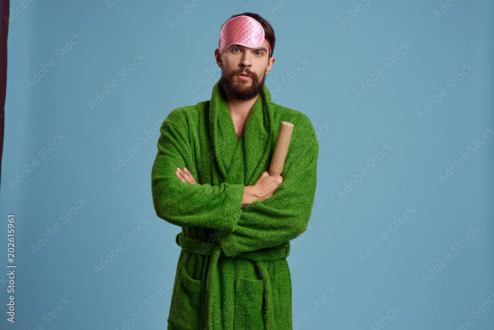 a man with a sleep mask on his head and in a green robe a man with a sleep mask on his head and in a green robe