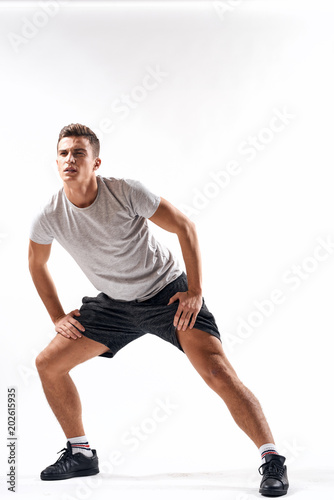 man in shorts and t-shirt spread her legs sport fitness