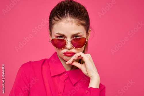 frustrated woman with glasses on a pink background pouting © SHOTPRIME STUDIO