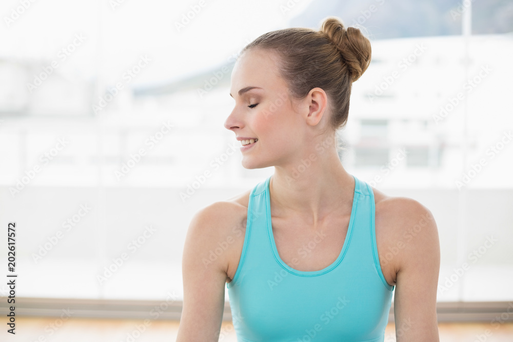 Sporty smiling woman looking away with closed eyes