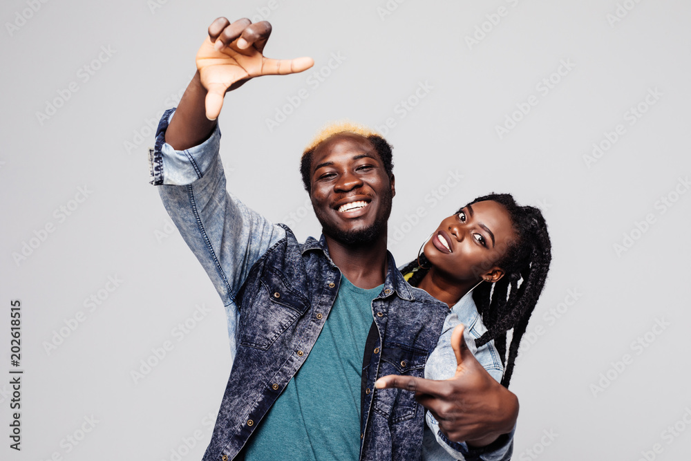 Φωτογραφία Portrait of a happy afro american couple make frame gesture isolated over white
