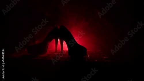 Black suede high heel women shoes on dark toned foggy background. Close up. Women power or women domination concept. Selective focus. Slider shot