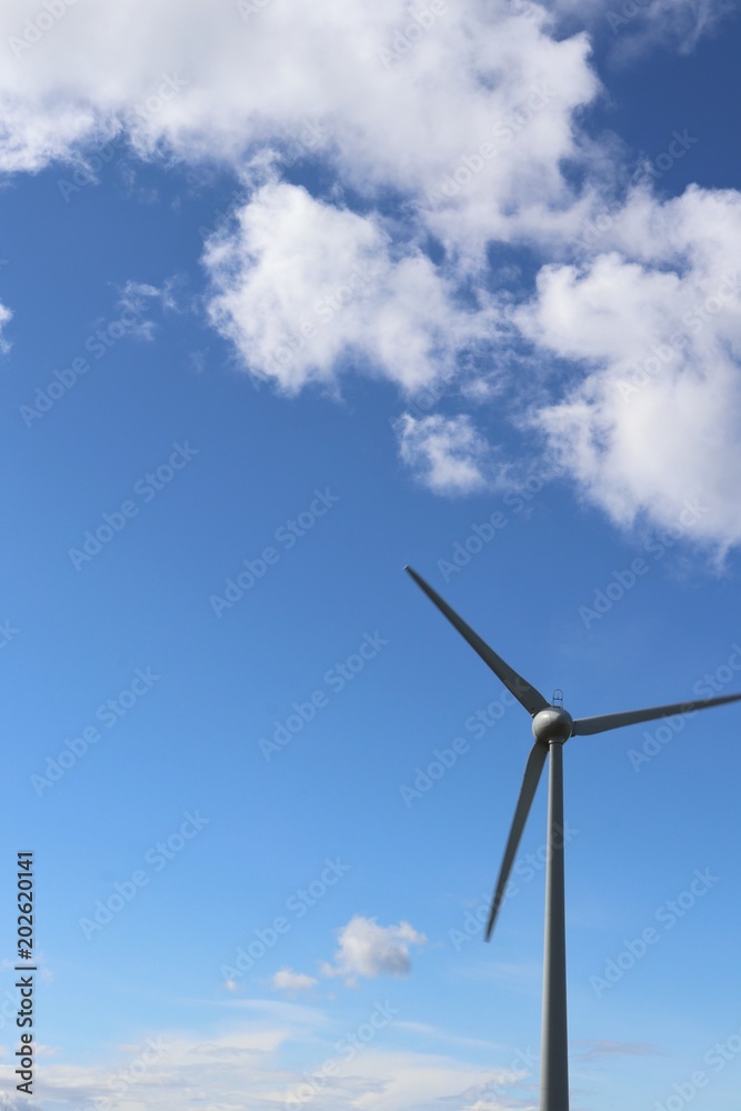 Wind tturbines against blue sky with fluffy white clouds Wind tturbines against blue sky with fluffy white clouds