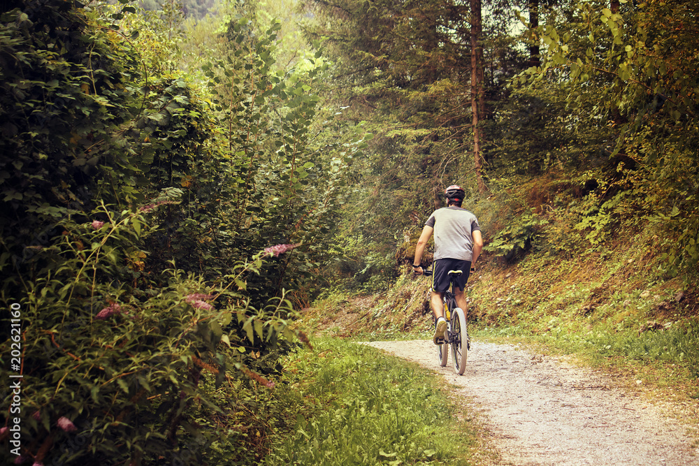 Obraz premium mountain bike training with copy space, warm tone image of a young man working out on a off road path