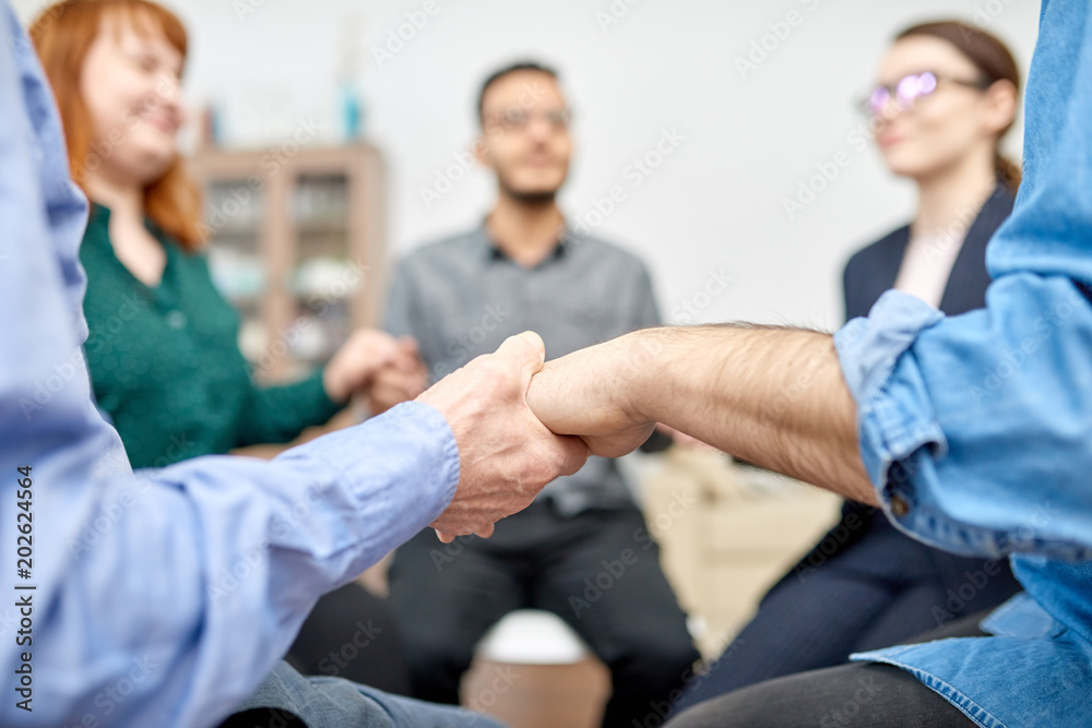 Φωτογραφία Close-up shot of male and female patients with closed eyes sitting in circle and