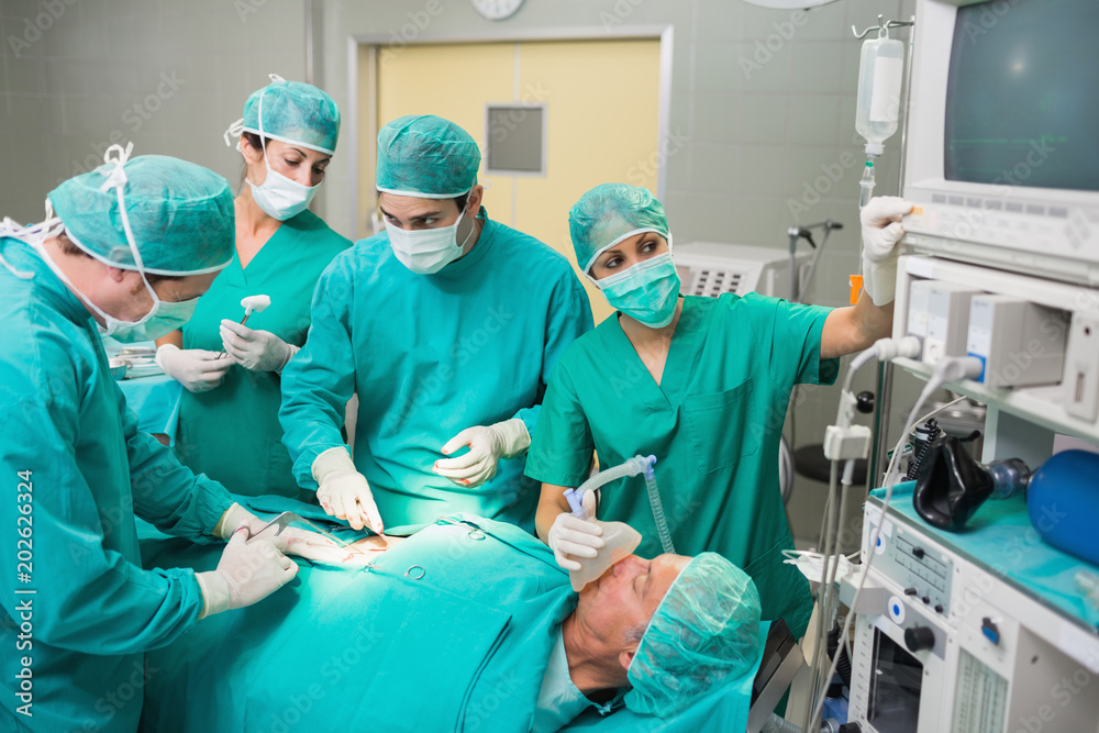 Nurse adjusting a monitor next to a patient Nurse adjusting a monitor next to a patient