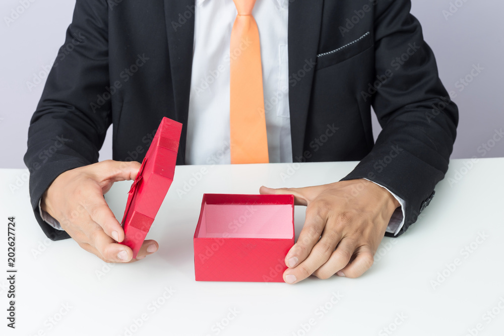 Φωτογραφία Businessman holds out the gift red box, isolated background