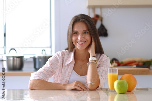 Young woman sitting a table in the kitchen. Young woman