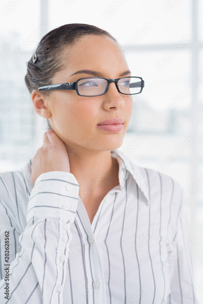 Thoughtful businesswoman with reading glasses standing in office Thoughtful businesswoman with reading glasses standing in office