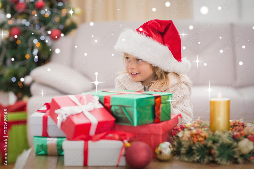 Cute little girl surrounded by christmas gifts against snow