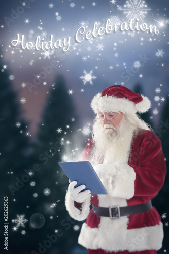 Santa uses a tablet PC against fir tree forest © vectorfusionart