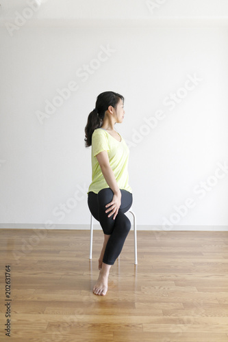 椅子を使ったストレッチ運動をする女性