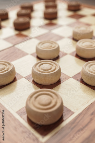 wooden draughts board game on brown table