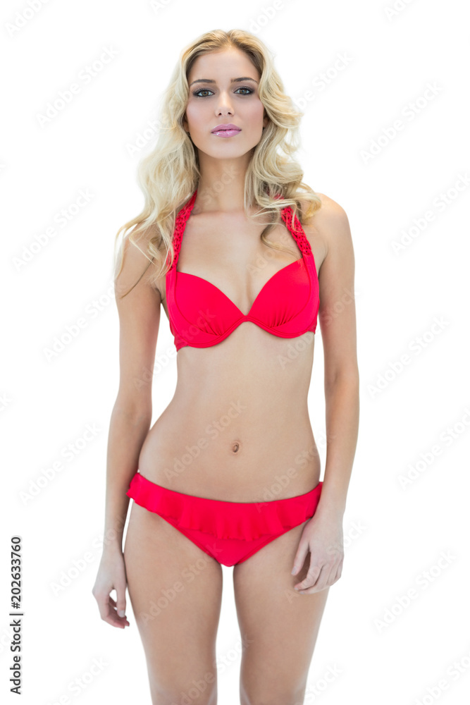 Pretty serious blonde model looking at camera wearing bikini