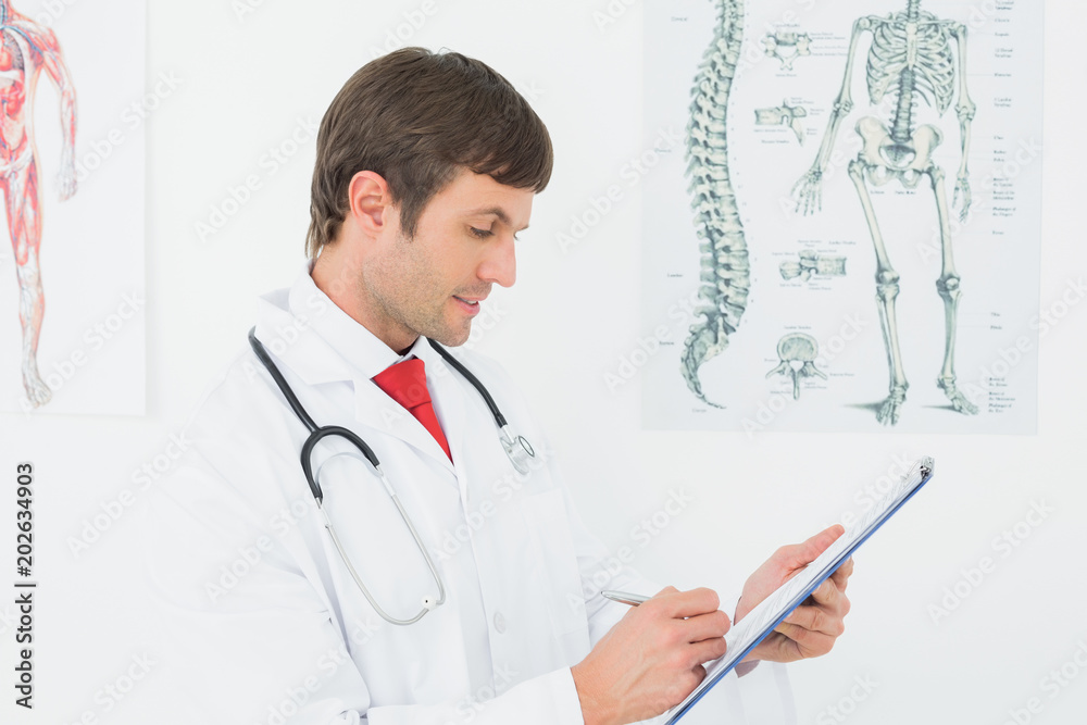 Concentrated male doctor writing reports Concentrated male doctor writing reports