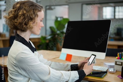 Photography Woman sitting at desk and using mobile phone