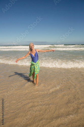 Portrait of smiling woman walking on shore