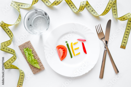 measuring tape and a plate with the word "diet" of vegetables