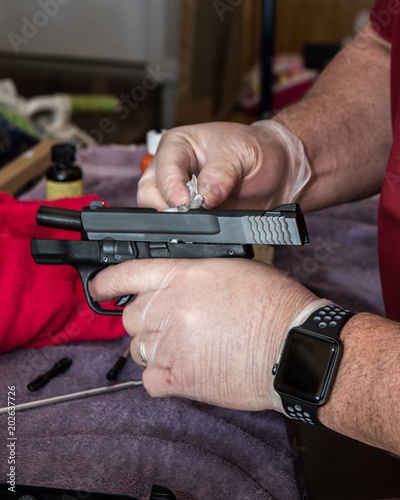 MAN CLEANING 9MM PISTOL © darcy
