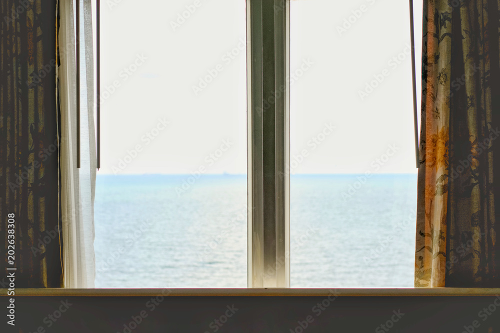 Window of the hotel with sea view in the morning time.