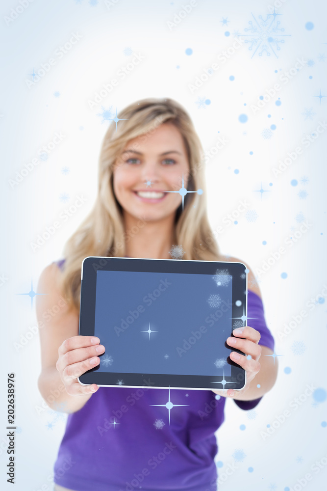 Composite image of Tablet computer being held by a blonde woman with snow falling Composite image of Tablet computer being held by a blonde woman with snow falling