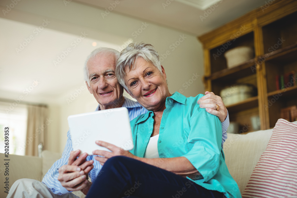Senior couple using digital tablet in living room Senior couple using digital tablet in living room