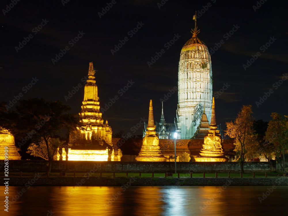 Scenery night view of Wat Phutthaisawan temple, which is archaeological or historic site, or ancient remains, with reflection in Chao Phraya River, Phra Nakhon Si Ayutthaya province, Thailand