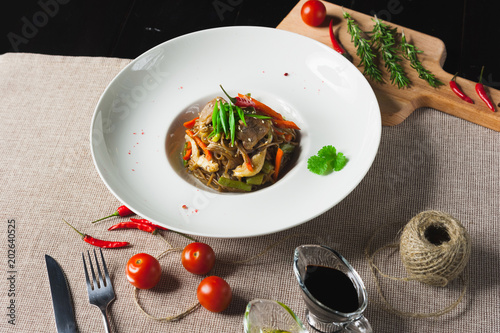 Healthy pasta with meat and vegetables on a white plate with with herbs and pepper photo