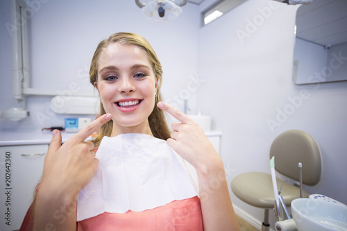 Smiling female patient sitting on dentists chair