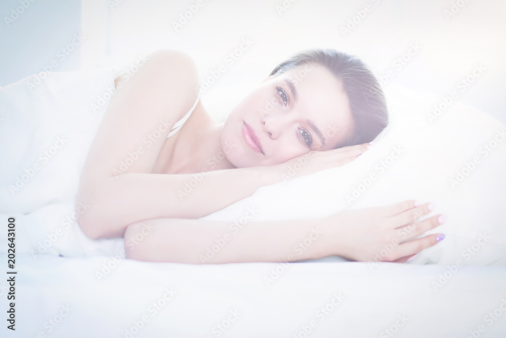 Pretty woman lying down on her bed at home