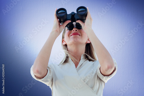 Businesswoman looking through binoculars against digitally generated grey vignette background © vectorfusionart