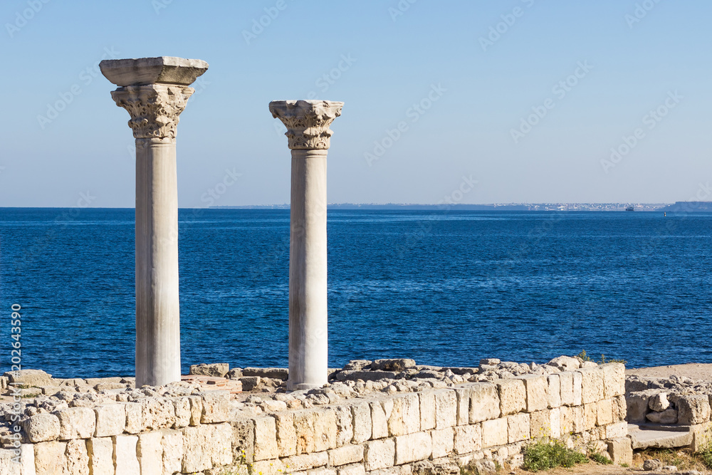 Two columns from the excavations of the ancient basilica in Chersonese against the background of the sea