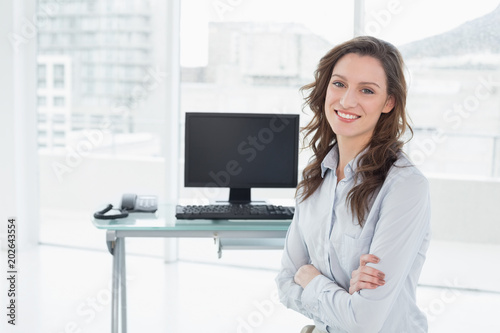 Smiling businesswoman in front of computer at office