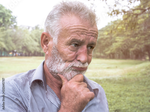 close-up portrait of old man standing thinking in evening time, emotions and feelings