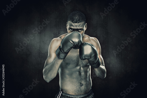 Muscular boxer against dark background